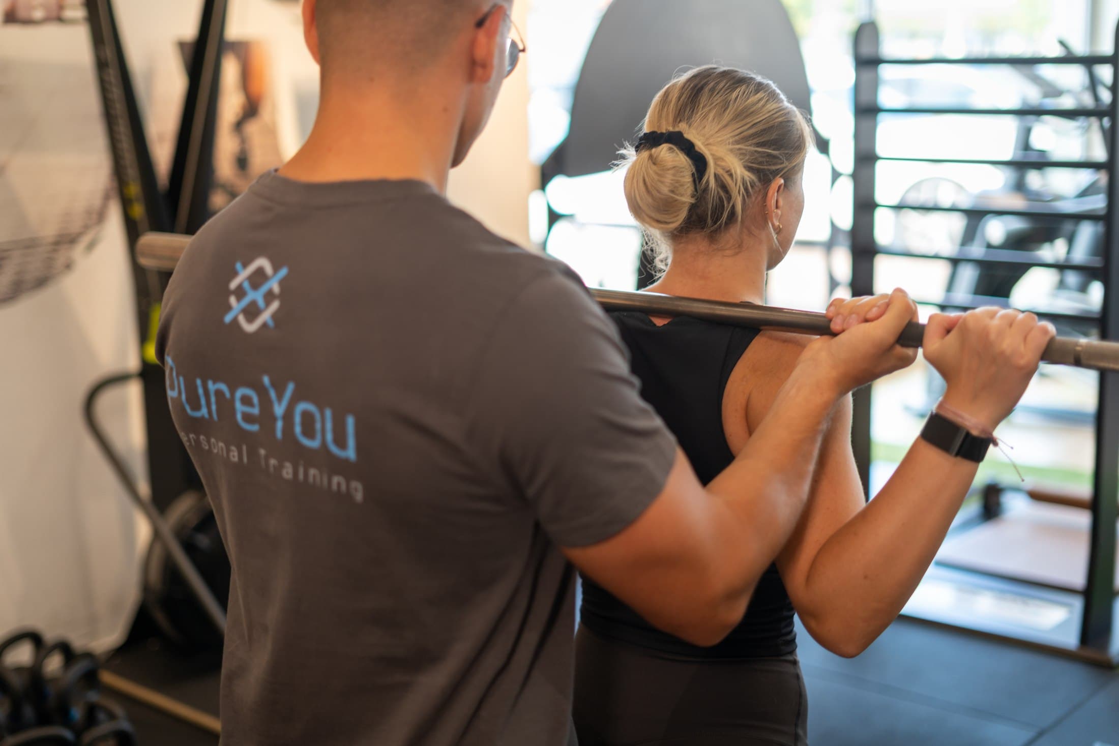 Personal Trainer begleitet eine Klientin beim Krafttraining