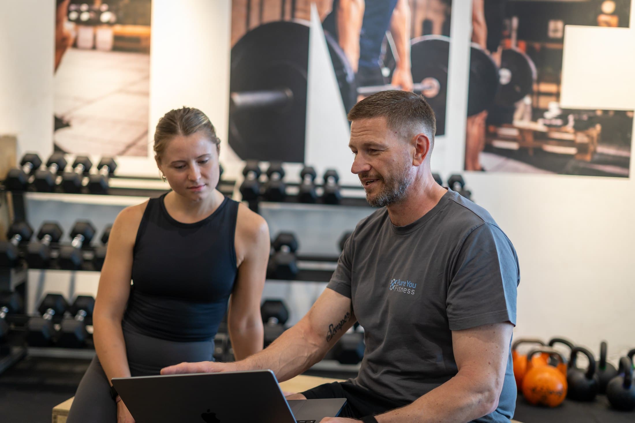 Trainer bespricht Trainingsdaten gemeinsam mit einer Klientin